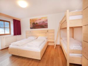 平茨高谷地瓦尔德Apartment in Wald im Pinzgau near the ski lifts的一间带两张双层床的卧室和楼梯