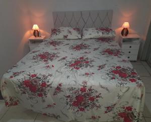 una camera da letto con un letto con fiori rossi di Cantinho Descanvida Temporada a Água Boa