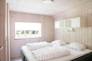 Un dormitorio con una cama en una habitación con ventana. en 10069-Rorvig-Harestykket-3, en Rørvig