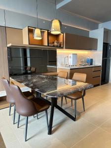 eine Küche mit einem großen Tisch und Stühlen in der Unterkunft Antara Genting by Enigma 2BR, High Floor in Genting Highlands