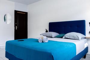 a blue bed with two clocks on top of it at A340 - City center room Papeete in Papeete +6 photos