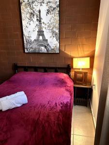 Un dormitorio con una cama roja y una imagen de la Torre Eiffel. en apartamento robles, en Santa Cruz Huatulco