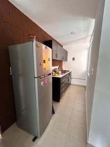 Una cocina con refrigerador de acero inoxidable en una habitación. en apartamento robles, en Santa Cruz Huatulco 14 fotos más