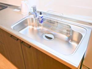 a stainless steel sink with a dish rack in it at 新大阪ゲストハウス 新大阪駅徒歩5分のリノベーション貸切宿 in Osaka +93 photos