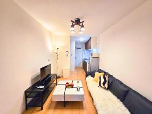 a living room with a black couch and a table at 新大阪ゲストハウス 新大阪駅徒歩5分のリノベーション貸切宿 in Osaka