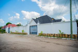 un edificio bianco con tetto nero di BNJ Royal Palace a Dar es Salaam