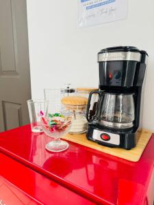 San FranciscoにあるRefugio Cálido en San Francisco de Heredia Baño Privado y Excelente Ubicaciónのコーヒーメーカーと食べ物の入ったボウルが置かれた赤いカウンター