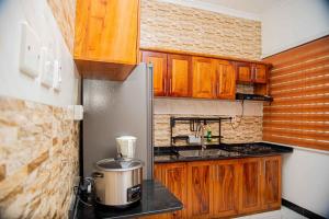una piccola cucina con armadi in legno e frigorifero di BNJ Royal Palace a Dar es Salaam