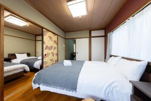 a bedroom with two beds and a window at HITOYADO kanazawa in Kanazawa