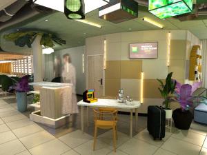 uma pessoa entrando em uma loja com uma mesa e cadeiras em ibis Styles Béziers Centre em Béziers