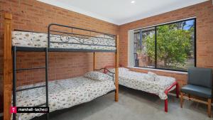 Giường trong phòng chung tại Cuttagee Beach Cottages, 6