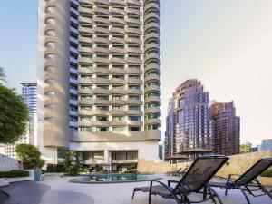 um grande edifício com cadeiras em frente em Novotel Kuala Lumpur City Centre em Kuala Lumpur