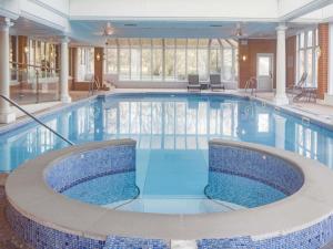 a large pool with blue water in a building at Mercure Blackburn Dunkenhalgh Hotel & Spa in Blackburn