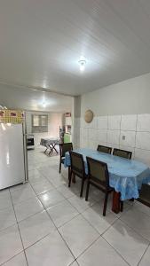 uma sala com uma mesa, cadeiras e uma geladeira em Casa de Temporadas Alto Bonito em Luis Correia