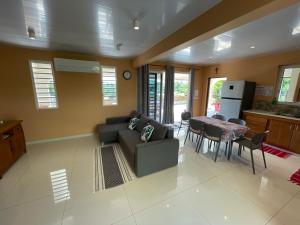 una sala de estar con un sofá y una mesa en Parahimai Lodge, en Farehau