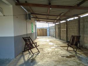 duas cadeiras vazias em um corredor vazio em Casa de Temporadas Alto Bonito em Luis Correia