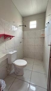 um banheiro branco com vaso sanitário e chuveiro em Casa de Temporadas Alto Bonito em Luis Correia