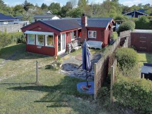 een rood huis met een paraplu ervoor bij FJ1003-Jaegerspris-Strandkrogen-2-A in Jægerspris