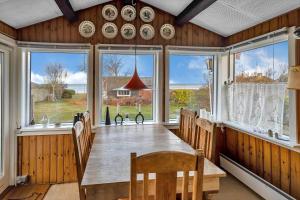 een eetkamer met een tafel en een aantal ramen bij FJ1003-Jaegerspris-Strandkrogen-2-A in Jægerspris