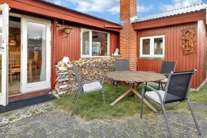 een houten tafel en stoelen voor een gebouw bij FJ1003-Jaegerspris-Strandkrogen-2-A in Jægerspris +10 foto's