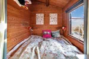 een slaapkamer met een bed in een kamer met houten wanden bij FJ1003-Jaegerspris-Strandkrogen-2-A in Jægerspris