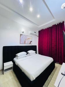 una camera da letto con un letto grande con una tenda rossa di SPECIAL LUXURY FOUR BEDROOM at LEKKI a Lekki