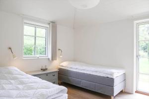 尼克宾西兰岛11126-1-Nykobing-Sj-Slaenhaekken-18的有两张床和两扇窗户的卧室