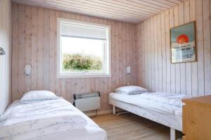 Dos camas en una habitación con ventana. en 13311-1-Asnaes-Hove-Straede-42-C, en Høve Strand