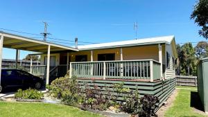 a house with a car parked in front of it at Tanjil Cottage in Lakes Entrance +7 photos