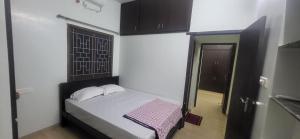 a small bedroom with a bed and a window at Serene Steps Orion in Coimbatore