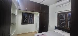 a bedroom with brown cabinets and a bed and a window at Serene Steps Orion in Coimbatore