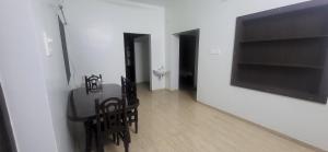 a dining room with a table and chairs and a television at Serene Steps Orion in Coimbatore