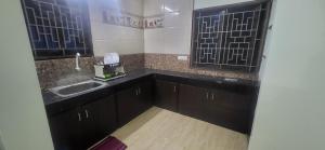 a small kitchen with a sink and a counter top at Serene Steps Orion in Coimbatore