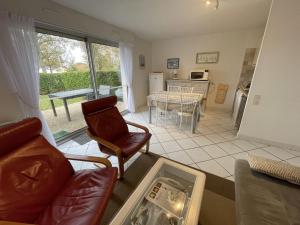 a living room with a couch and a chair and a table at Appartement rez-de-jardin proche Port Crouesty, 4 pers, tennis, piscine, wifi - FR-1-775-50 in Arzon