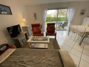 a living room with a couch and a tv at Appartement rez-de-jardin proche Port Crouesty, 4 pers, tennis, piscine, wifi - FR-1-775-50 in Arzon