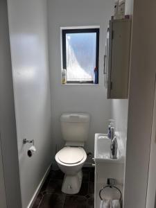 ein kleines Badezimmer mit Toilette und Waschbecken in der Unterkunft Lime Street Retreat in Invercargill + 1 Foto