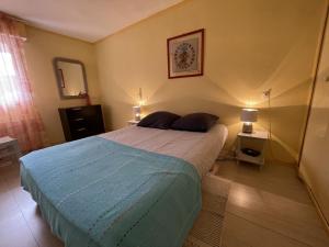 a bedroom with a large bed with a blue blanket at Appartement rez-de-jardin proche Port Crouesty, 4 pers, tennis, piscine, wifi - FR-1-775-50 in Arzon +7 photos