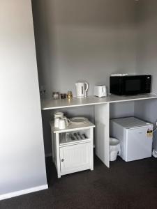 eine Küche mit einer Arbeitsfläche, auf der eine Mikrowelle steht in der Unterkunft Lime Street Retreat in Invercargill