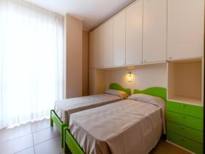 a bedroom with two beds and a green cabinet at Alba Adriatica apartments charm in Alba Adriatica