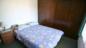 una camera da letto con un letto e un armadio in legno di Fisherman's Cabin - 11 Mill Street Affordable, fishing friendly a Bermagui