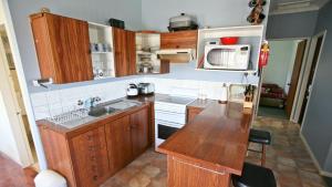 una piccola cucina con lavello e frigorifero di Fisherman's Cabin - 11 Mill Street Affordable, fishing friendly a Bermagui
