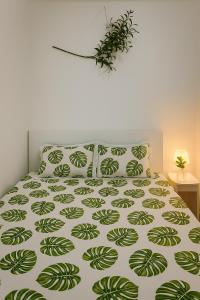 Bett mit einer grünen und weißen Bettdecke und Kissen in der Unterkunft Wecomstay Vinhomes Grand Park in Gò Công