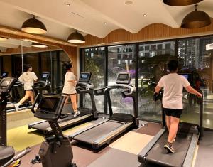 eine Gruppe von Menschen, die in einem Fitnessstudio auf Laufbändern laufen in der Unterkunft Wecomstay Vinhomes Grand Park in Gò Công
