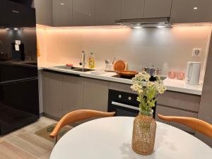 eine Küche mit einem Tisch mit einer Vase mit Blumen darauf in der Unterkunft Wecomstay Vinhomes Grand Park in Gò Công