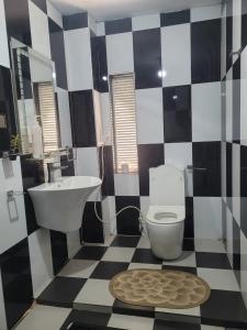 Baño en blanco y negro con aseo y lavamanos en Beehive mountain resident, en Kandy