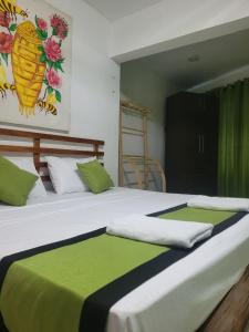1 dormitorio con 2 camas con sábanas verdes y blancas en Beehive mountain resident, en Kandy
