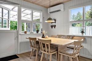uma sala de jantar com mesa e cadeiras de madeira em LF15195-Hojslev-Sneppevej-25 em Nørre Ørum