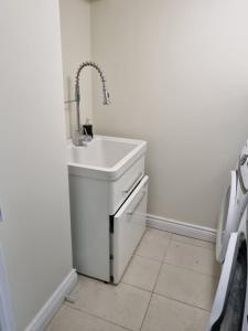 a white sink in a bathroom with a tiled floor at Newly Renovated 3BR Upper Unit - Bright & Quiet in Richmond Hill +15 photos