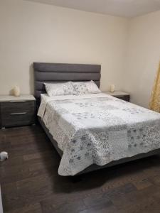 a bedroom with a bed with two nightstands and two tables at Newly Renovated 3BR Upper Unit - Bright & Quiet in Richmond Hill