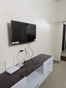 a living room with a tv on a wall at Sri Abirami Homestays in Tiruvannāmalai